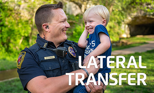 male police officer outdoors holding his young son and text: lateral transfer